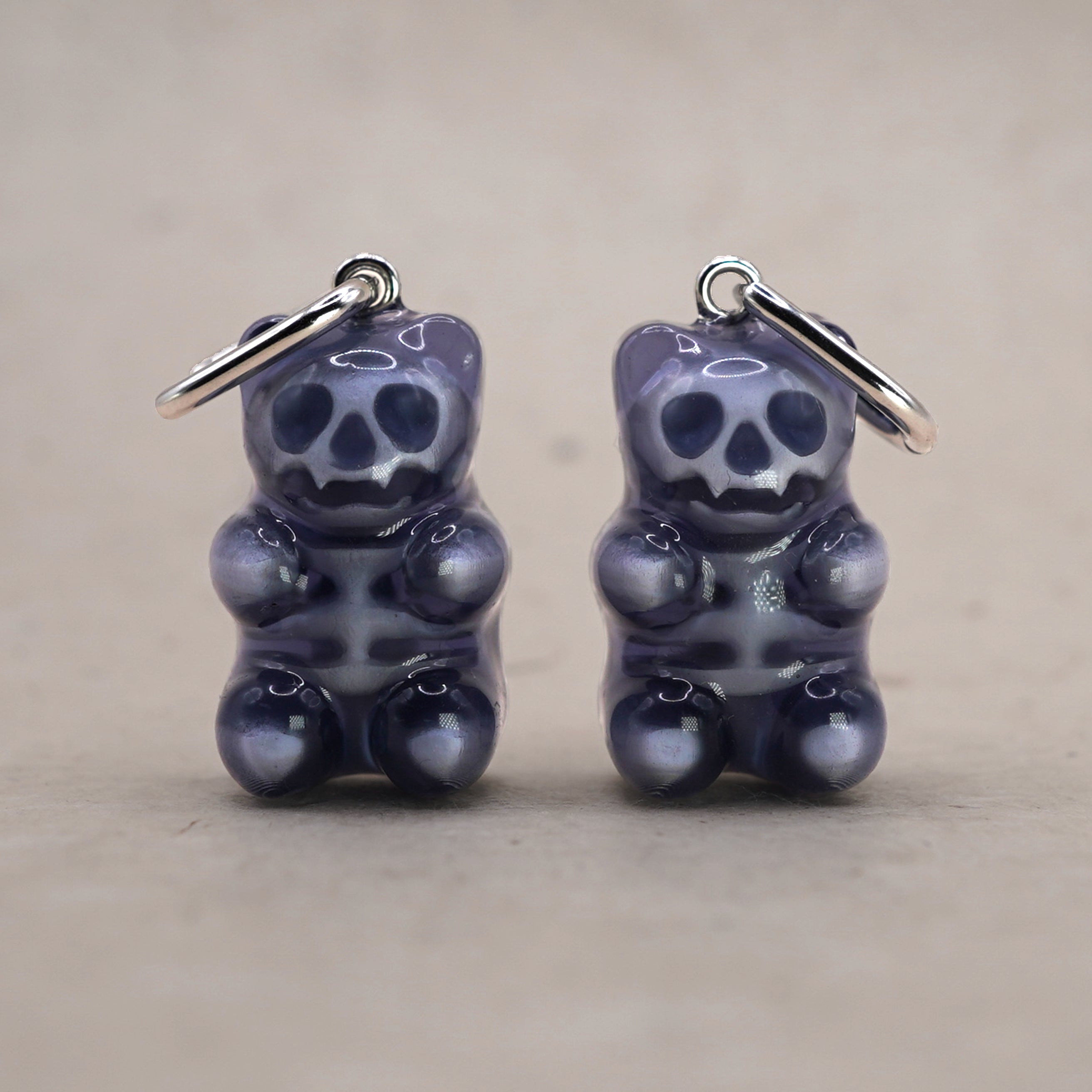 Transparent gummy bear skeleton earrings made of glossy resin, gothic candy-inspired jewelry with visible skull and bones