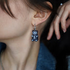 Close-up of transparent resin gummy bear skeleton earring, glossy handmade
