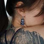 Close-up of transparent resin gummy bear skeleton earring, glossy handmade