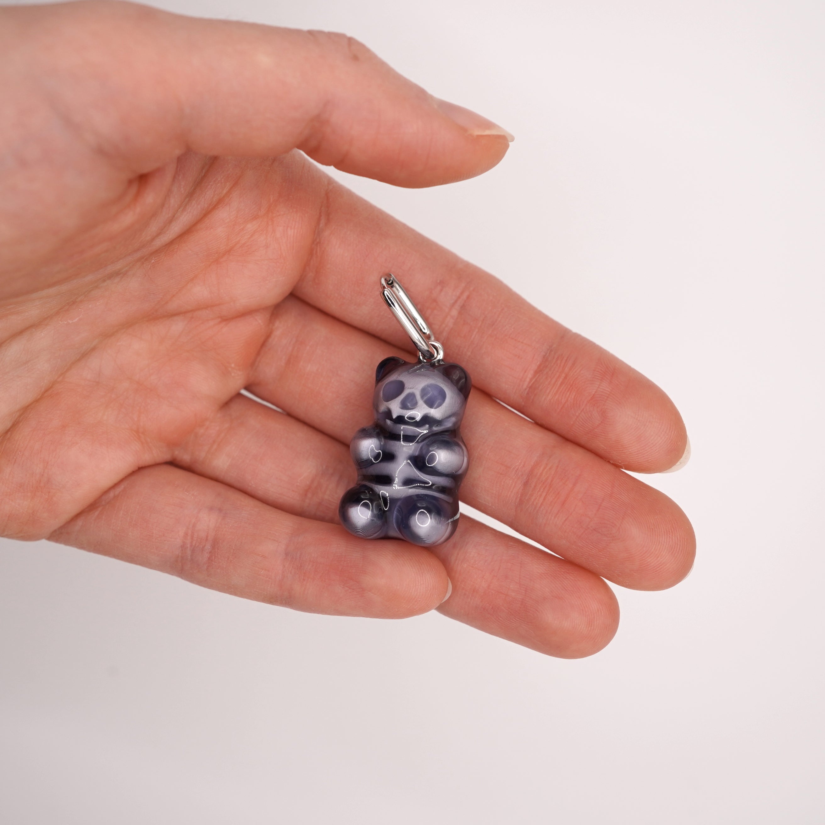 Front view of clear gummy bear skeleton earrings with skull face, glossy resin candy bear jewelry, spooky cute gothic accessory