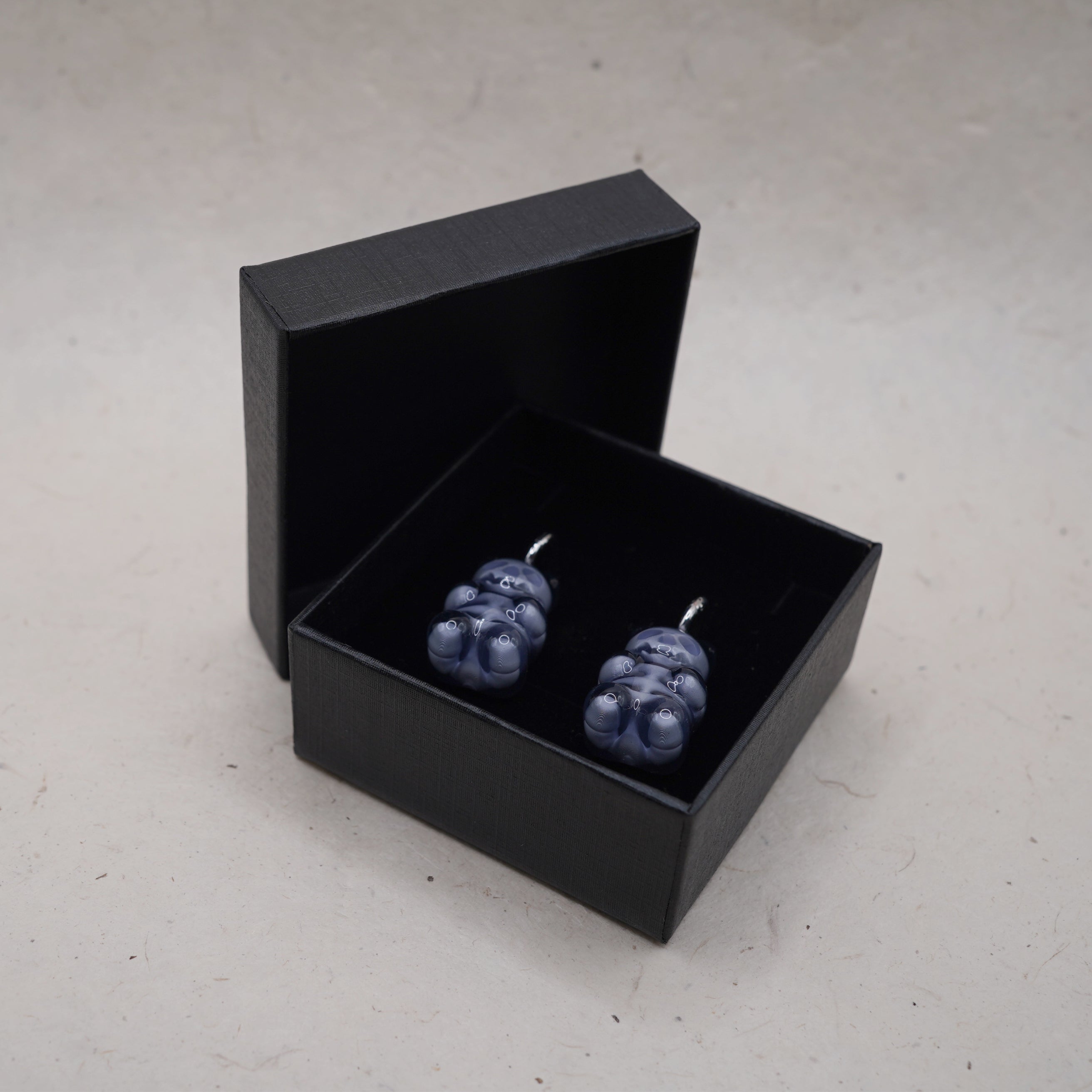 Dark transparent gummy bear skeleton earrings displayed in black gift box, glossy resin gothic handmade jewelry