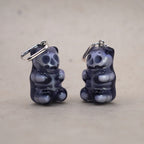 Mini transparent gummy bear skeleton earring shown in hand for scale, handmade resin skull bear charm, creepy cute gothic jewelry design
