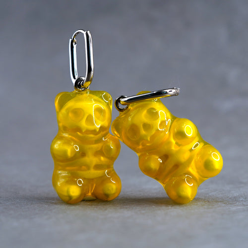 Pair of yellow transparent gummy bear skeleton earrings in glossy resin, cute spooky candy-inspired handmade jewelry