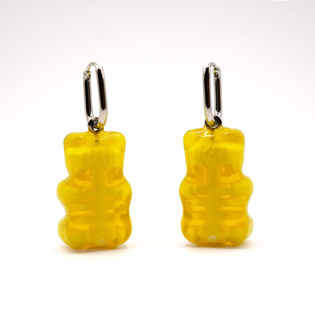 Back view of yellow gummy bear skeleton earrings, translucent resin showing rib cage and spine detail