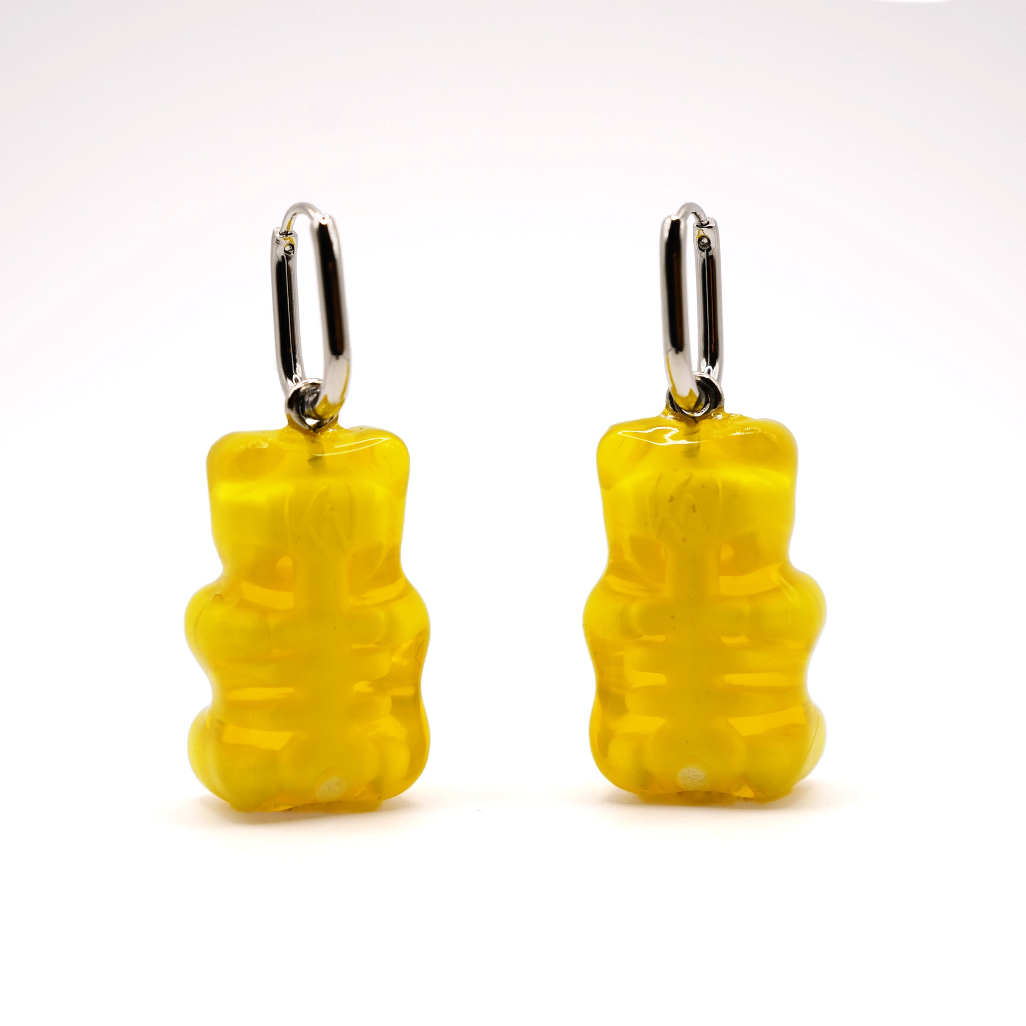 Back view of yellow gummy bear skeleton earrings, translucent resin showing rib cage and spine detail