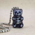 Black X-Ray gummy bear pendant with visible skull and ribcage, glossy resin charm on silver ball chain, front view close-up.