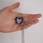 Handheld spiked heart charm showing glass-like shine, transparent black resin heart with spikes and broken heart accent