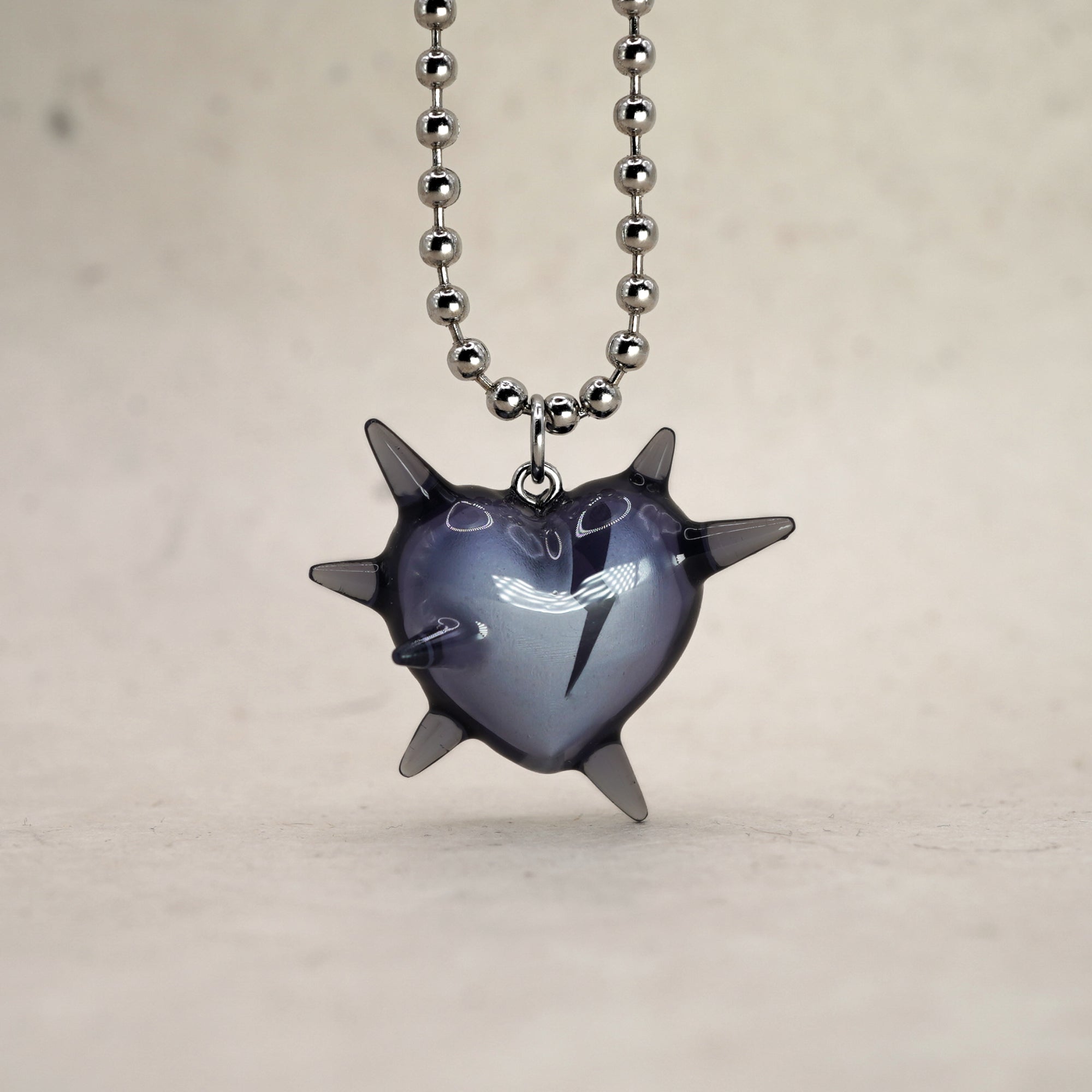 Spiked heart pendant necklace in transparent black resin, broken heart detail, rhodium plated ball chain, alternative luxury jewelry