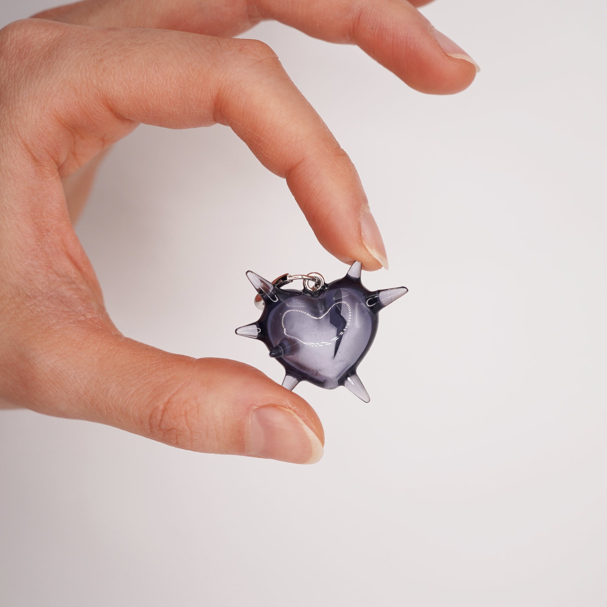 Spiked broken heart earring worn on ear, translucent resin gothic jewelry with dark romantic symbolism